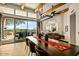 Expansive dining room features rustic wood beams, tile floors, designer lighting, and access to an outdoor living area at 10767 E Santa Fe Trl, Scottsdale, AZ 85262