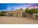 Home exterior featuring a two-car garage, desert landscaping, and a wrought iron gate entrance at 10767 E Santa Fe Trl, Scottsdale, AZ 85262