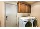 Laundry room with washer, dryer, storage, and a door at 10767 E Santa Fe Trl, Scottsdale, AZ 85262