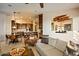 Open-concept living area with a view of the kitchen, decorative ceiling beams, and comfortable seating arrangements at 10767 E Santa Fe Trl, Scottsdale, AZ 85262