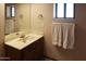 Bathroom featuring a vanity with a marble countertop, mirror, and decorative towel racks at 11406 W Montana Ave, Youngtown, AZ 85363