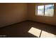 Spacious bedroom with ample natural light from the window overlooking the yard at 11406 W Montana Ave, Youngtown, AZ 85363