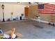 Organized garage interior with ample space, including an American flag on the brick wall at 11406 W Montana Ave, Youngtown, AZ 85363