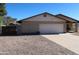 Two-car garage with a concrete driveway and adjacent gravel area at 11406 W Montana Ave, Youngtown, AZ 85363