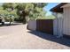 Side yard with gravel and trees; fence blocks view to neighboring yards at 11406 W Montana Ave, Youngtown, AZ 85363