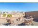 Charming backyard seating area with comfortable wicker chairs, a modern fire pit, and scenic neighborhood views at 12686 E Pivot Peak --, Gold Canyon, AZ 85118