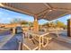 Community barbecue area with a grill, shaded picnic tables and a well-maintained landscape at 12686 E Pivot Peak --, Gold Canyon, AZ 85118