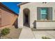 Inviting home entrance featuring an arched doorway, shuttered window and low maintenance landscaping at 12686 E Pivot Peak --, Gold Canyon, AZ 85118