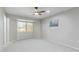 Light-filled bedroom with a ceiling fan, neutral carpet, and large window providing plenty of natural light at 12706 W Shadow Hills Dr, Sun City West, AZ 85375