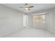 Airy bedroom with a ceiling fan, neutral carpet, and large window providing plenty of natural light at 12706 W Shadow Hills Dr, Sun City West, AZ 85375