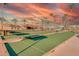 Enjoy the outdoor bocce ball court with palm trees, seating, and a building in the background at 12706 W Shadow Hills Dr, Sun City West, AZ 85375