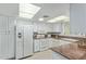 Bright kitchen featuring white appliances, light cabinets, and granite countertops at 12706 W Shadow Hills Dr, Sun City West, AZ 85375