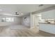 Open-concept living room flowing into kitchen featuring light gray walls and modern ceiling fan at 12706 W Shadow Hills Dr, Sun City West, AZ 85375