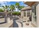 Cozy back patio with desert landscaping, seating, and views of palm trees at 15542 W Cypress Point Dr, Surprise, AZ 85374