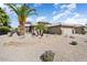 A beautiful home featuring desert landscaping with palms and a stone facade at 15542 W Cypress Point Dr, Surprise, AZ 85374