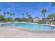 Large community pool with palm trees, lounge chairs, and a clubhouse for residents' enjoyment at 17143 W Oberlin Way, Surprise, AZ 85387