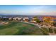 Aerial view of homes with green lawns adjacent to the green of the golf course and mountain views at 1805 E Atole Pl, Queen Creek, AZ 85140