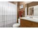 Well-maintained bathroom featuring a shower-tub combo, wood vanity, and framed mirror at 1805 E Atole Pl, Queen Creek, AZ 85140