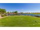 Scenic golf course featuring a picturesque lake, waterfall, and perfectly manicured green fairways at 1805 E Atole Pl, Queen Creek, AZ 85140