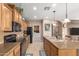 Well-lit kitchen featuring wood cabinetry, granite countertops, tile backsplash, and stainless steel appliances at 1805 E Atole Pl, Queen Creek, AZ 85140