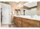 Bright bathroom featuring double sinks, wooden cabinetry, a large mirror, and ample counter space at 1805 E Atole Pl, Queen Creek, AZ 85140