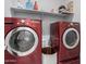 Modern laundry room boasts red washer and dryer with shelving and storage at 18400 E Donato Dr, Gold Canyon, AZ 85118