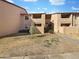 Two-story condo building showcasing a common walkway and front lawn on a sunny day at 1942 S Emerson -- # 217, Mesa, AZ 85210