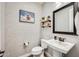 Half bathroom with a pedestal sink, decorative shelves, and rustic artwork at 1950 E Lantana Dr, Chandler, AZ 85286