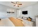 Main bedroom with a king bed, mounted TV, bench, and neutral-colored decor at 1950 E Lantana Dr, Chandler, AZ 85286