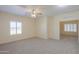 Spacious bedroom featuring neutral carpet, plantation shutters, and a ceiling fan at 1980 N Santa Fe Ct, Casa Grande, AZ 85122