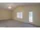 Bright living room with ceiling fan, large window, neutral carpet, and access to the outdoors at 1980 N Santa Fe Ct, Casa Grande, AZ 85122