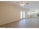 Living room featuring tiled floors, neutral walls, ceiling fan, and glass doors to the backyard at 1980 N Santa Fe Ct, Casa Grande, AZ 85122