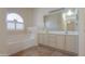 Well-lit main bathroom features dual sinks, a large mirror, and a relaxing soaking tub with a window at 1980 N Santa Fe Ct, Casa Grande, AZ 85122