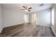 Large bedroom featuring a ceiling fan, wood-look floors, and doorway to the bathroom at 22473 W Woodlands Ave, Buckeye, AZ 85326