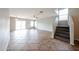 Living room featuring tile floors and stair access to the second floor at 22473 W Woodlands Ave, Buckeye, AZ 85326