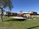 Community playground featuring play structures, picnic tables, and grassy areas at 22473 W Woodlands Ave, Buckeye, AZ 85326