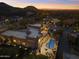 An evening aerial view showing the house and pool illuminated within the desert community at 24019 N 112Th Pl, Scottsdale, AZ 85255