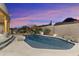 Beautiful backyard pool with lush desert landscaping, mountain views, and an illuminated patio area at 24019 N 112Th Pl, Scottsdale, AZ 85255