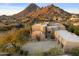 Exterior of a desert home with a circular driveway, desert landscaping, and mountain views at 24019 N 112Th Pl, Scottsdale, AZ 85255