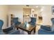 Inviting living room featuring stylish blue chairs and a unique copper-topped coffee table with a view to the dining room at 24019 N 112Th Pl, Scottsdale, AZ 85255