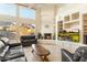 Inviting living room featuring high ceilings, a cozy fireplace, and large windows with scenic views at 24019 N 112Th Pl, Scottsdale, AZ 85255