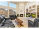 Bright living room with fireplace, media center, and desert views from large windows at 24019 N 112Th Pl, Scottsdale, AZ 85255