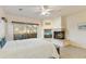 Bright primary bedroom featuring balcony access, a cozy fireplace, and picturesque mountain views at 24019 N 112Th Pl, Scottsdale, AZ 85255