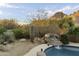 Beautiful backyard pool with rock waterfall feature surrounded by lush desert landscaping at 24019 N 112Th Pl, Scottsdale, AZ 85255