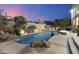 Beautiful pool with lush desert landscaping, waterfall feature and an illuminated patio area makes this backyard an oasis at 24019 N 112Th Pl, Scottsdale, AZ 85255