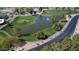 Scenic aerial view of the golf course with a tranquil pond surrounded by mature trees at 25820 S Saddletree Dr, Sun Lakes, AZ 85248