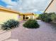 Private backyard showcasing mature desert landscaping, including bushes and stone walkways at 25820 S Saddletree Dr, Sun Lakes, AZ 85248