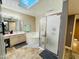 Bright bathroom featuring dual sinks, soaking tub, glass shower, and a skylight for natural light at 25820 S Saddletree Dr, Sun Lakes, AZ 85248