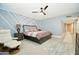 Spacious main bedroom featuring a ceiling fan, accent wall, and tile flooring at 25820 S Saddletree Dr, Sun Lakes, AZ 85248