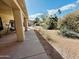 Covered patio overlooking a xeriscaped backyard with mature plants and sunny skies at 25820 S Saddletree Dr, Sun Lakes, AZ 85248